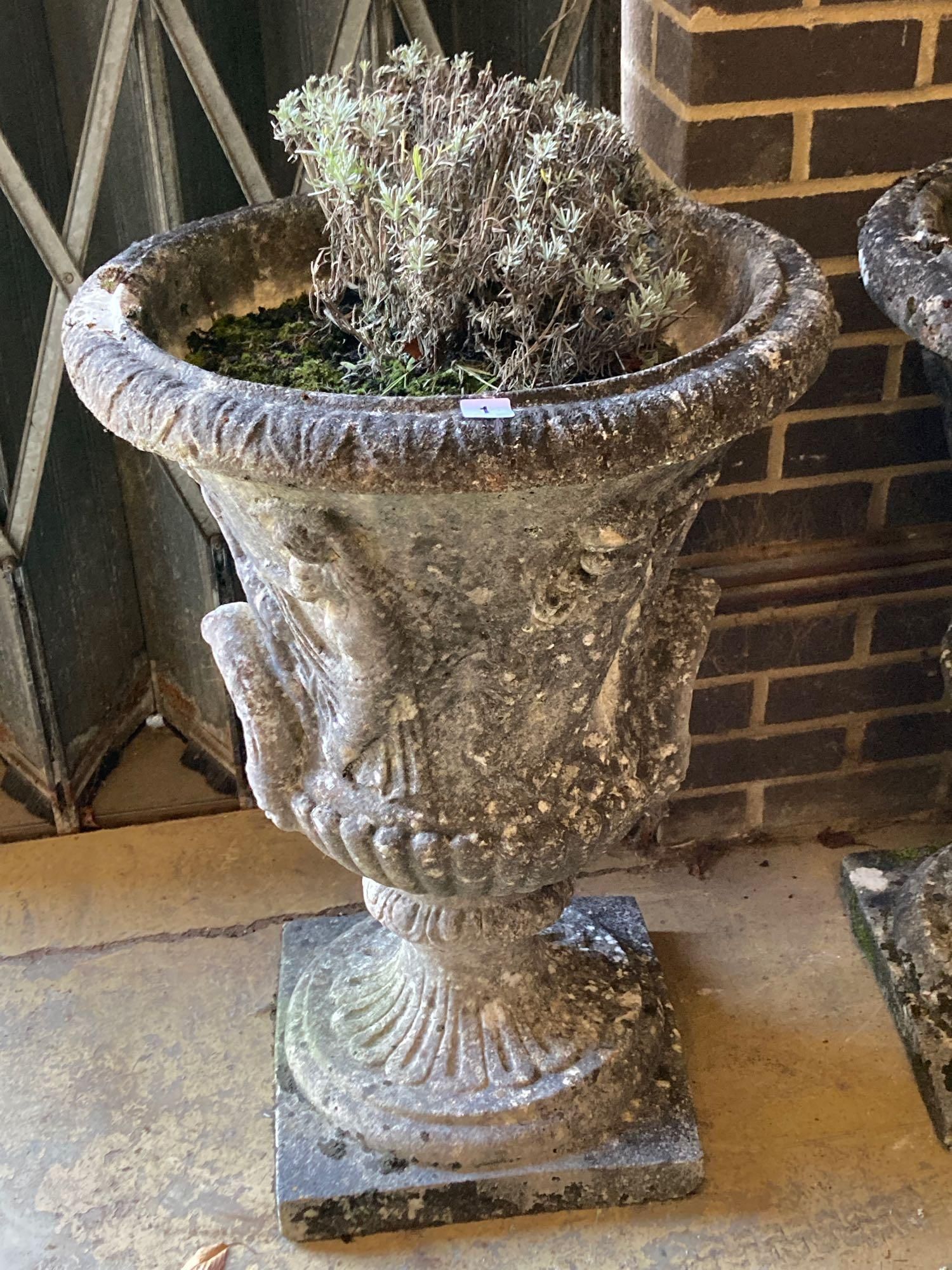 A pair of weathered composition stone urns and pedestals, diameter 56cm height 81cm